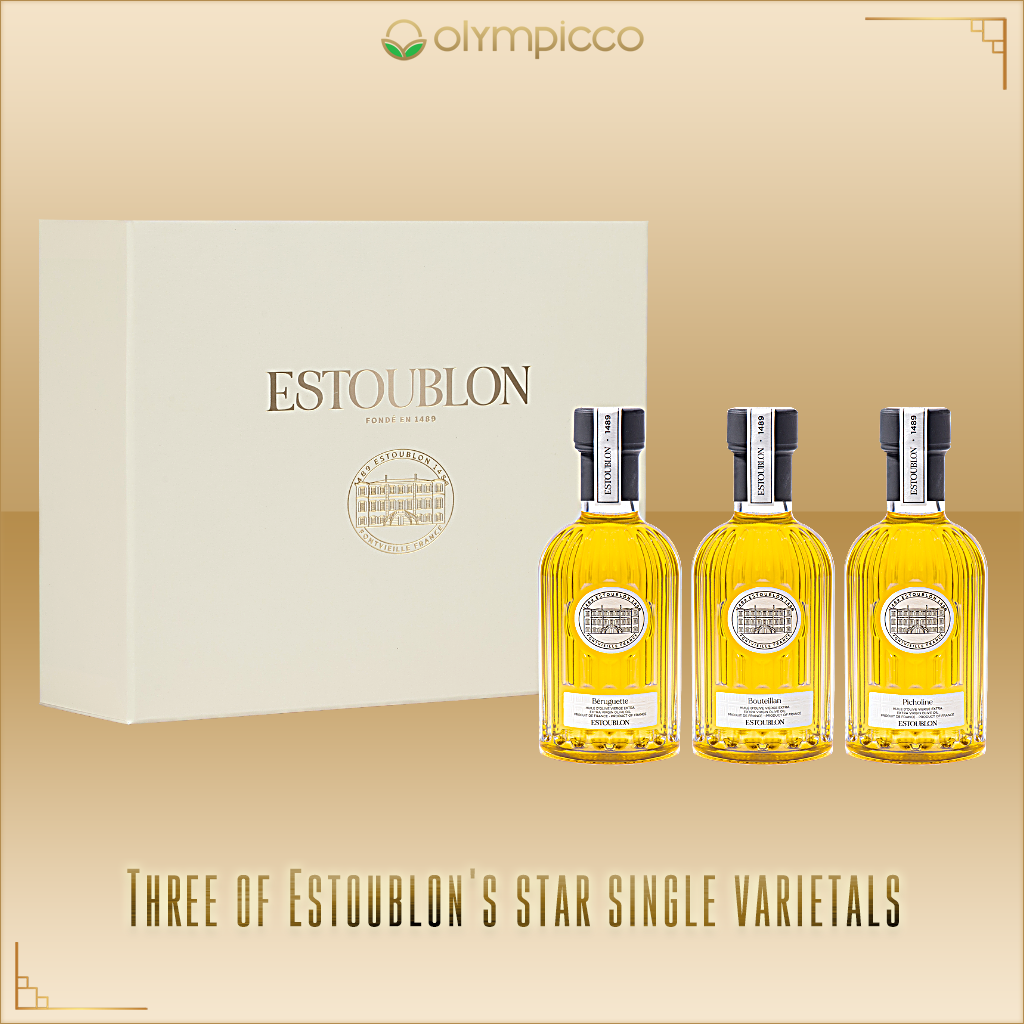 Three Estoublon bottles with a box on a beige background, featuring the Olympicco brand.