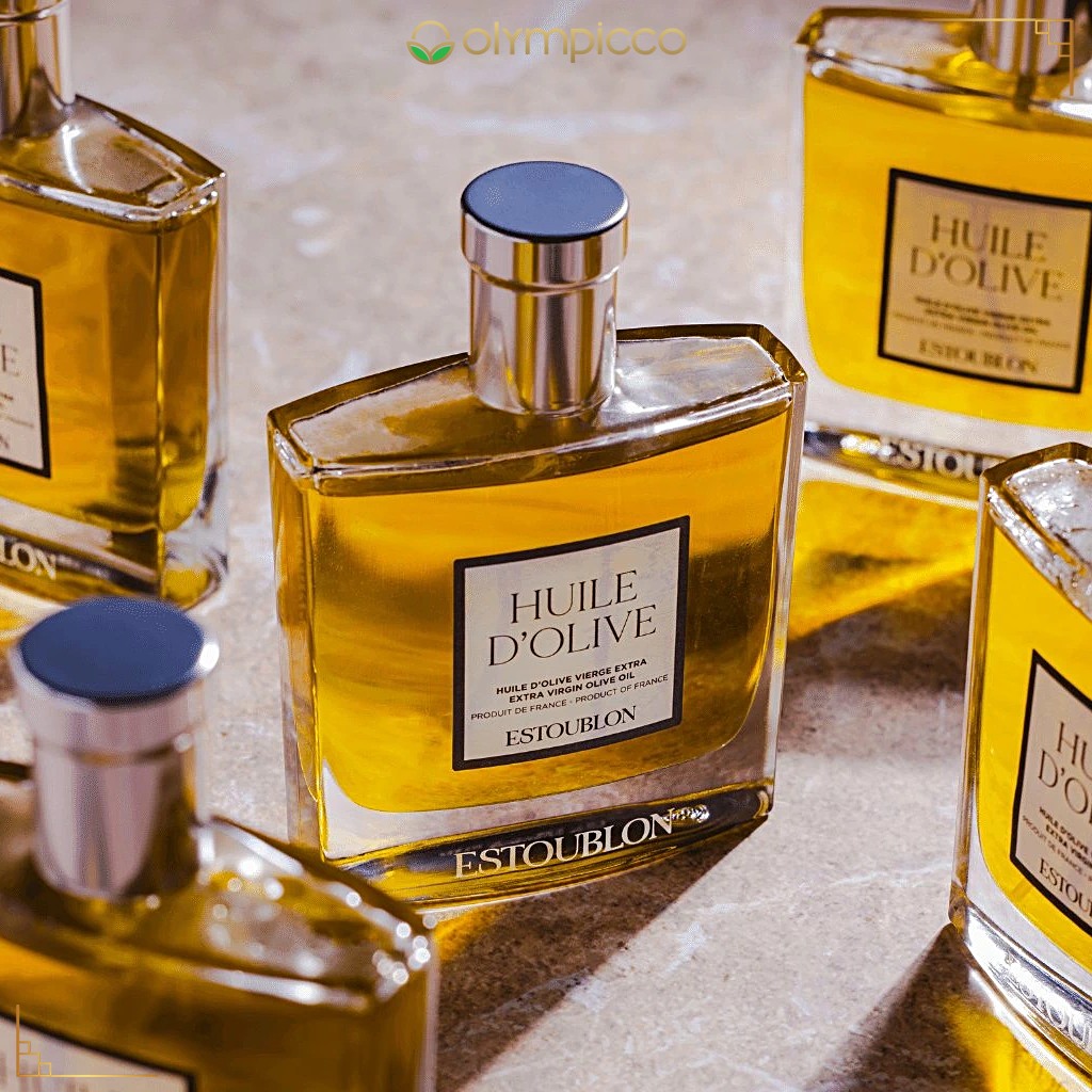 Estoublon Huile d'Olive bottles on a reflective surface with 'Olimpicco' branding.
