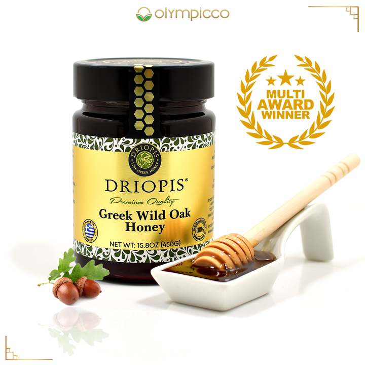 Jar of Driopis Greek Wild Oak Honey with a honey dipper and honeycomb on a white background, featuring Olympicco branding.