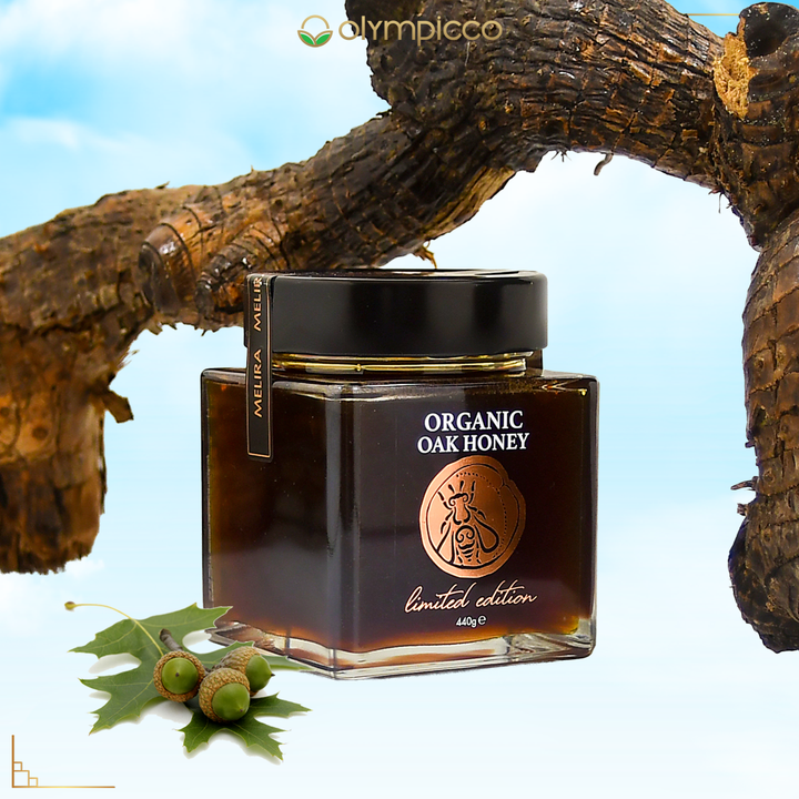Jar of organic oak honey with a tree branch and acorns in the background