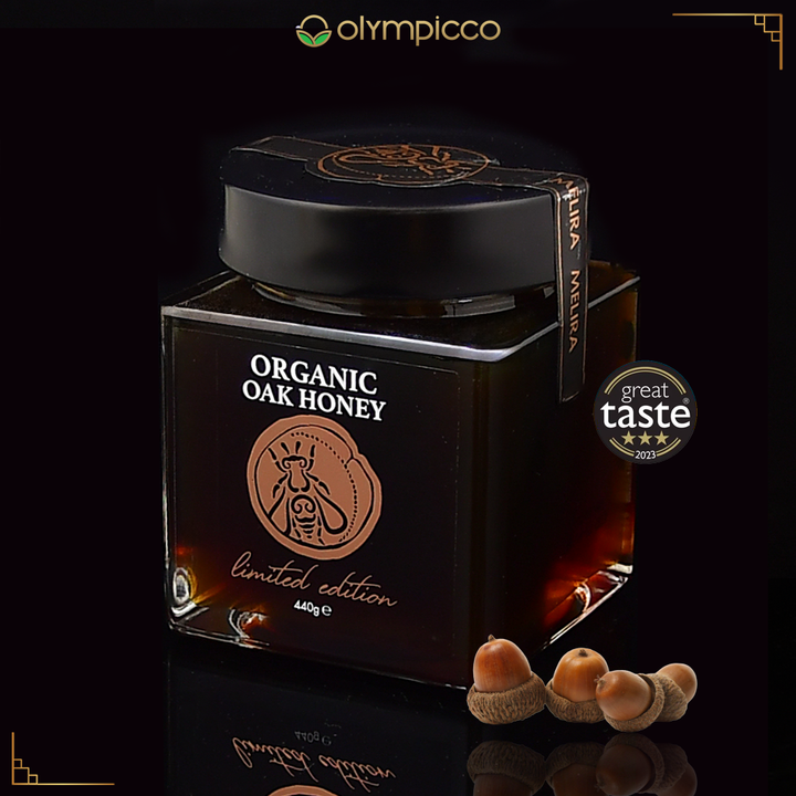 Jar of organic oak honey with 'Great Taste' award on a dark background, featuring Olympicco brand.